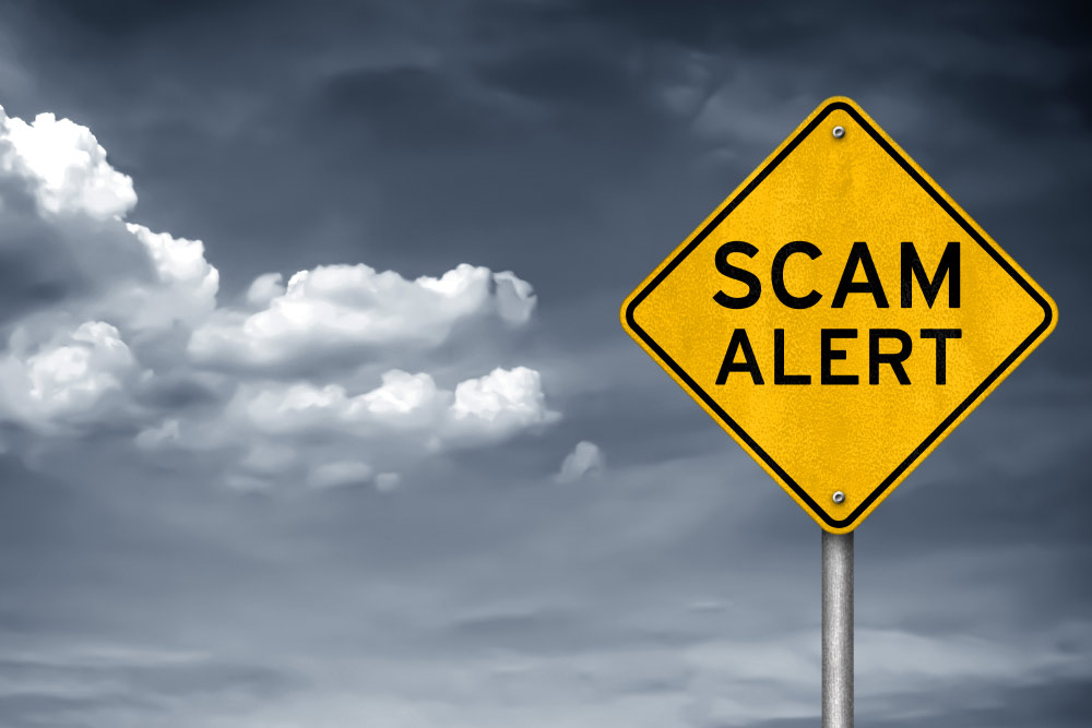 caution road sign stating scam alert